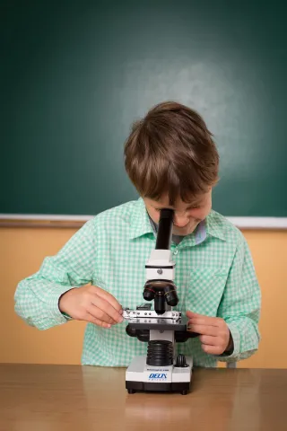 Boy looking at a microscope.