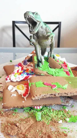 Toy Dinosaur wrecking a gingerbread house.
