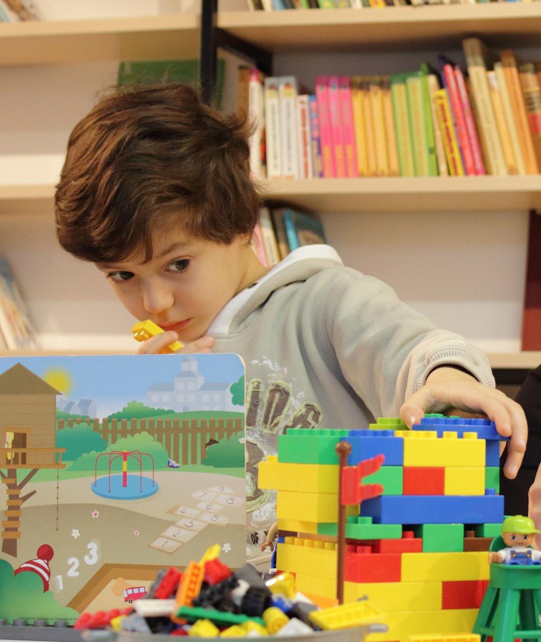 Boy in a library playing with Legos.