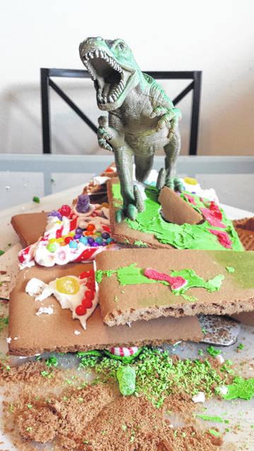 Toy Dinosaur wrecking a gingerbread house.